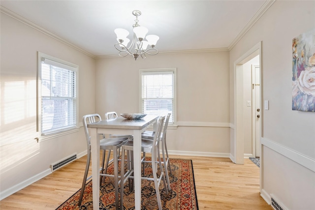 dining room featuring a notable chandelier, light hardwood / wood-style floors, and ornamental molding