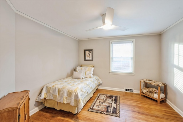 bedroom with ceiling fan, crown molding, and hardwood / wood-style floors