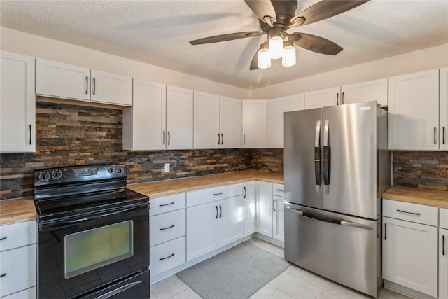 kitchen featuring black / electric stove, wood counters, white cabinets, tasteful backsplash, and stainless steel refrigerator