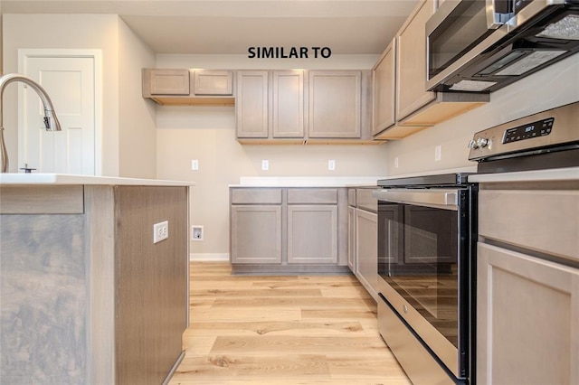 kitchen featuring appliances with stainless steel finishes, light wood-type flooring, and sink