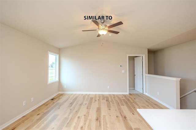 spare room featuring light hardwood / wood-style flooring, vaulted ceiling, and ceiling fan