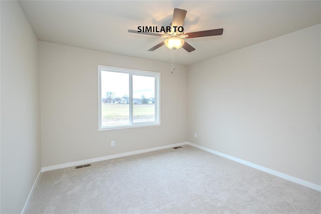 spare room with ceiling fan and light colored carpet