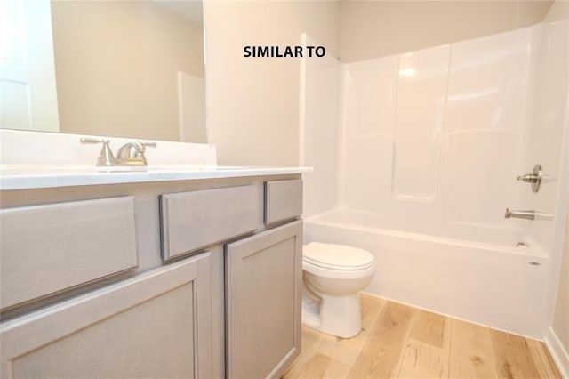 full bathroom featuring bathing tub / shower combination, hardwood / wood-style floors, vanity, and toilet