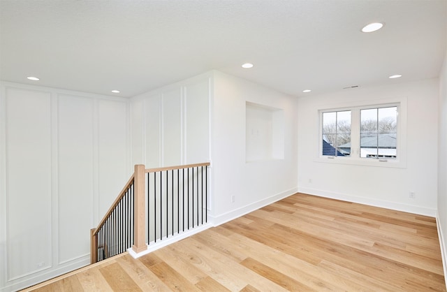 unfurnished room featuring recessed lighting, baseboards, and wood finished floors