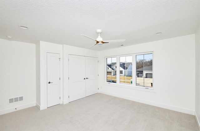 unfurnished bedroom with light carpet, visible vents, and baseboards