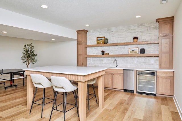 bar with wine cooler, indoor wet bar, light wood-style flooring, and tasteful backsplash