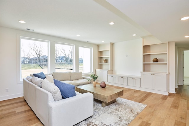 living area with light wood finished floors, recessed lighting, built in features, and baseboards