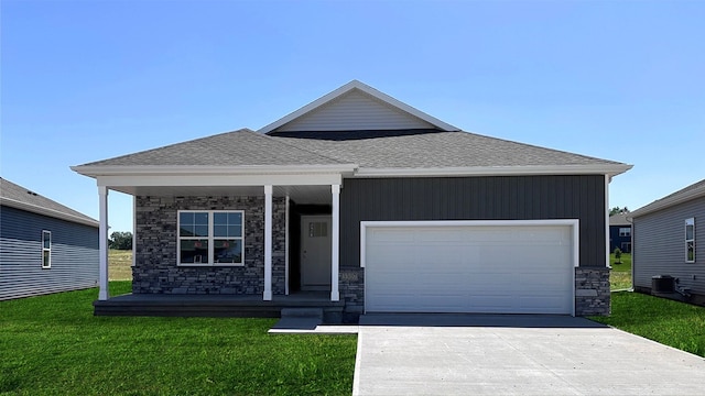 view of front of property with a front yard, a garage, and cooling unit