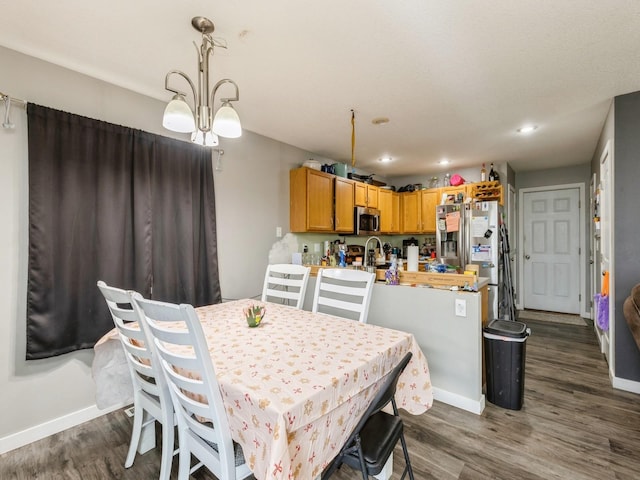 dining area featuring dark hardwood / wood-style floors and an inviting chandelier