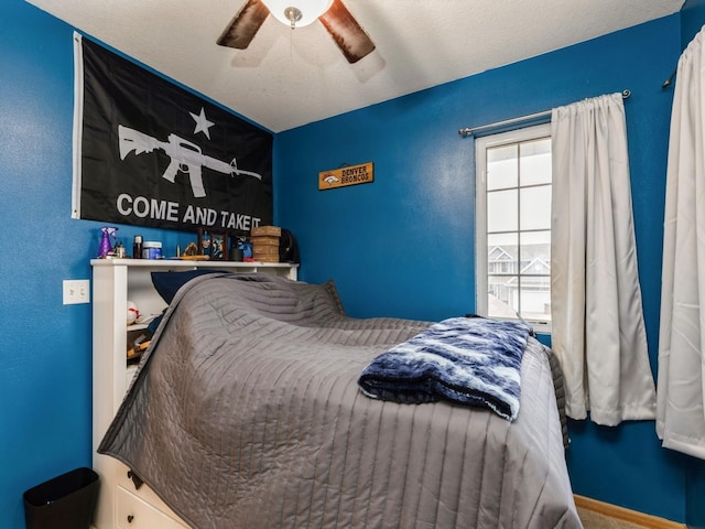 bedroom with ceiling fan and a textured ceiling