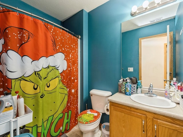 bathroom with vanity, a textured ceiling, and toilet