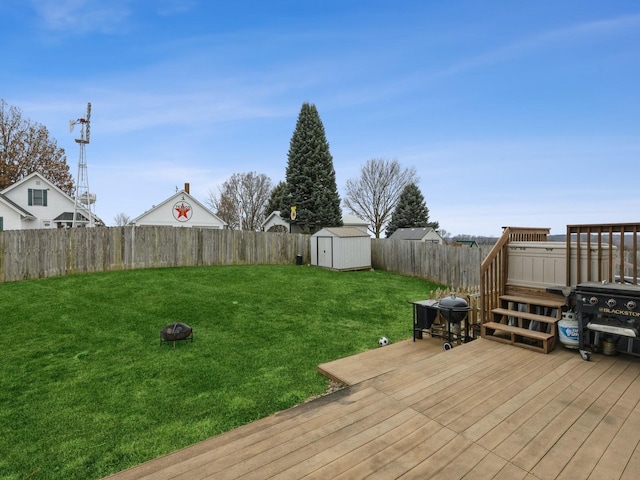 wooden terrace with a shed, an outdoor fire pit, and a lawn