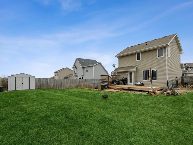 back of house featuring a lawn, a wooden deck, and a storage unit