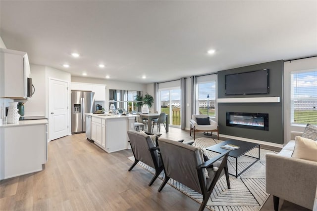 4408 NE 11th St, Ankeny, IA 50021 - living area featuring light wood-style floors, a glass covered fireplace, plenty of natural light, and recessed lighting