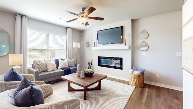 1155 Magnolia Ln, Waukee, IA 50263 - living area featuring ceiling fan, wood finished floors, and a glass covered fireplace