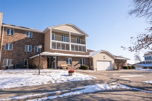 view of front of property featuring a balcony, cooling unit, and a garage