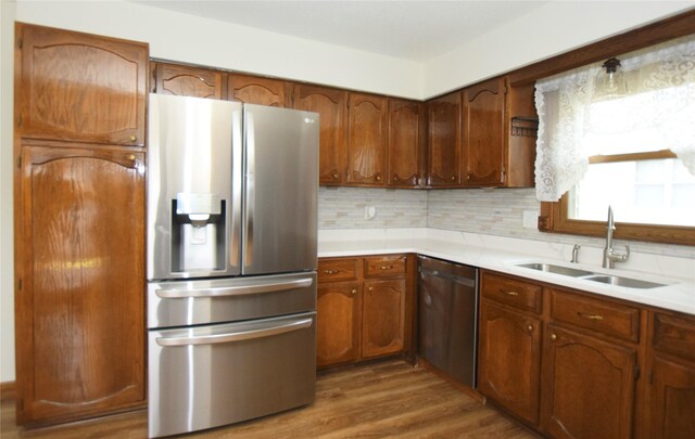 kitchen with backsplash, sink, dark hardwood / wood-style floors, and appliances with stainless steel finishes