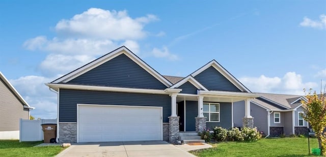 craftsman house with a garage and a front lawn