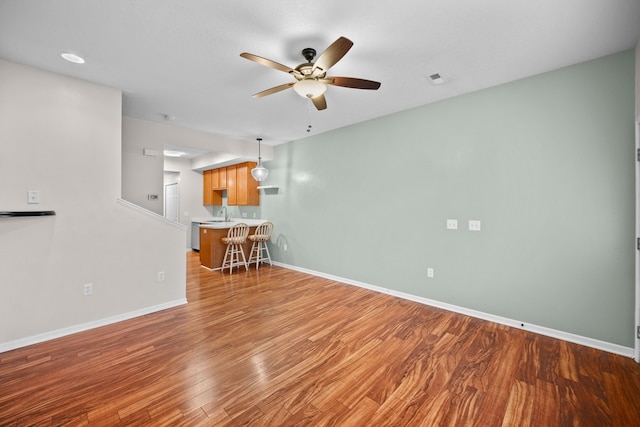 unfurnished living room featuring hardwood / wood-style flooring and ceiling fan