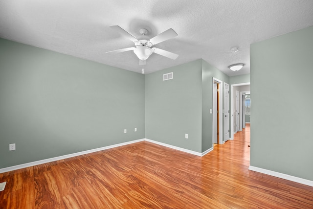 unfurnished room with ceiling fan, light hardwood / wood-style floors, and a textured ceiling