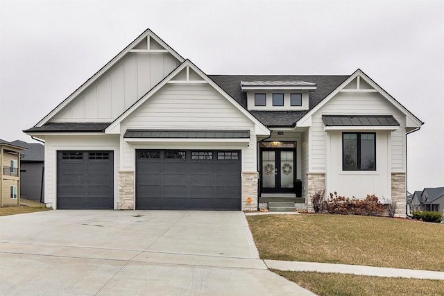 view of front of home featuring a garage, french doors, and a front lawn