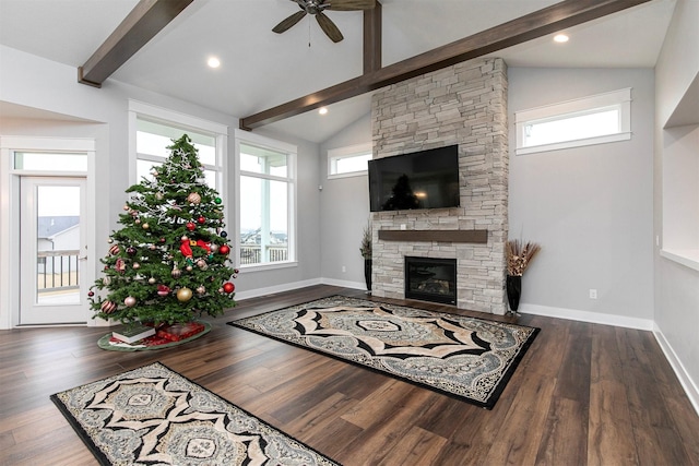 living room featuring a wealth of natural light, a fireplace, ceiling fan, and dark hardwood / wood-style floors