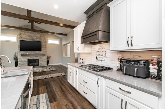 kitchen with premium range hood, sink, vaulted ceiling with beams, dark hardwood / wood-style flooring, and white cabinetry