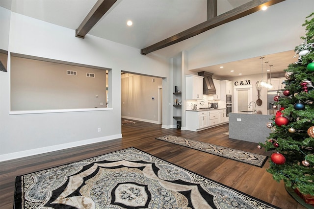 living room with beamed ceiling, dark hardwood / wood-style flooring, high vaulted ceiling, and sink