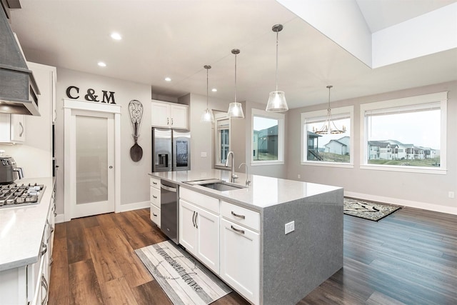 kitchen featuring sink, decorative light fixtures, a kitchen island with sink, white cabinets, and appliances with stainless steel finishes