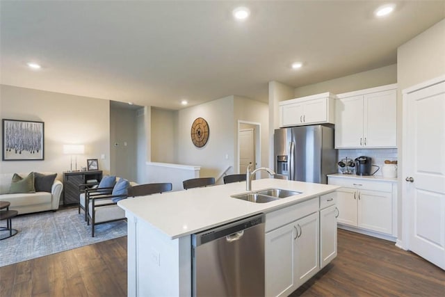 kitchen featuring white cabinets, appliances with stainless steel finishes, dark wood-type flooring, sink, and a center island with sink