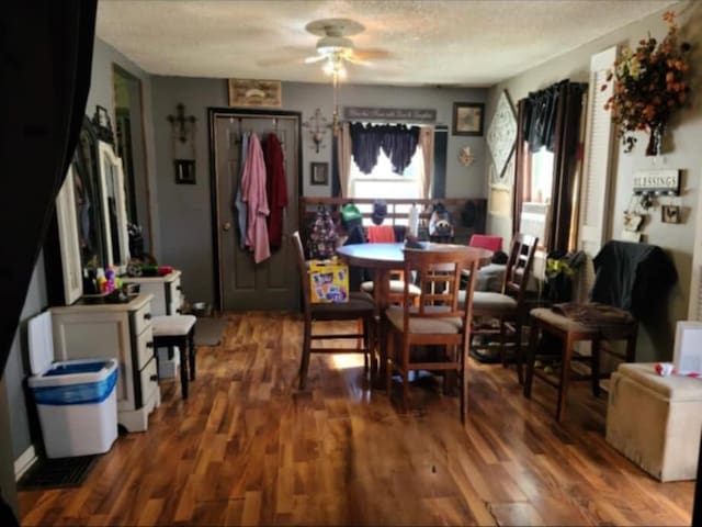 dining area with ceiling fan, hardwood / wood-style floors, and a textured ceiling