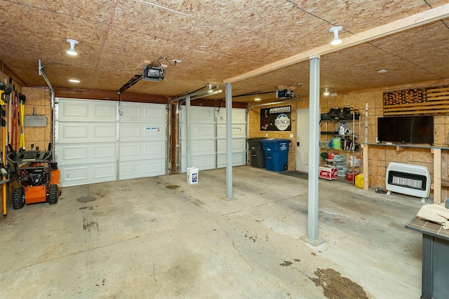 garage featuring heating unit and a garage door opener