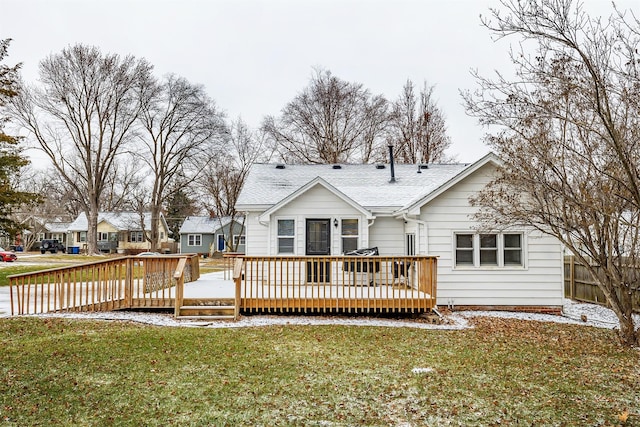 rear view of property featuring a deck and a lawn