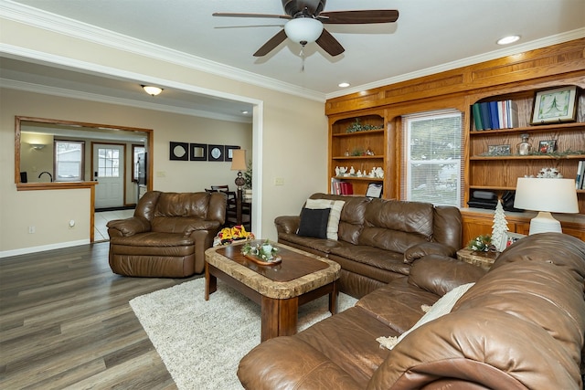 living room with built in shelves, ceiling fan, dark hardwood / wood-style floors, and crown molding