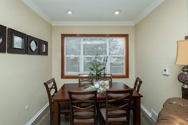 dining room with dark hardwood / wood-style flooring and crown molding