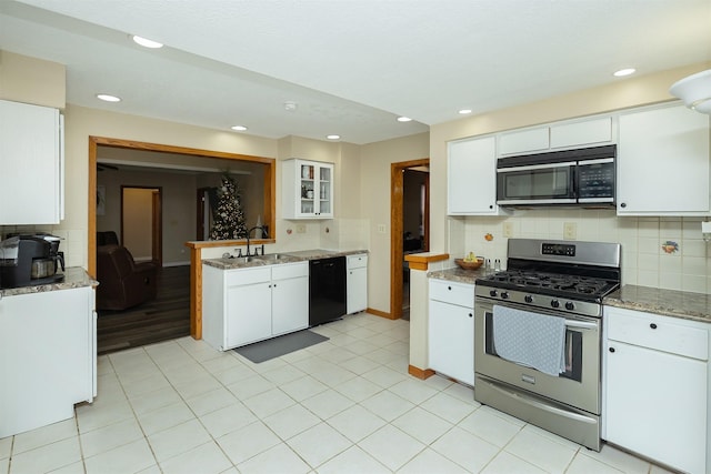 kitchen with stainless steel gas range oven, sink, decorative backsplash, black dishwasher, and white cabinetry