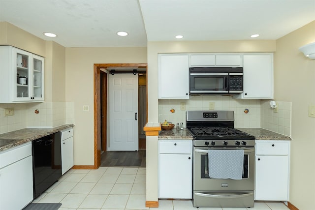 kitchen with black appliances, white cabinets, and backsplash