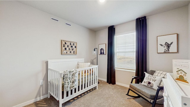 bedroom with light colored carpet and a nursery area