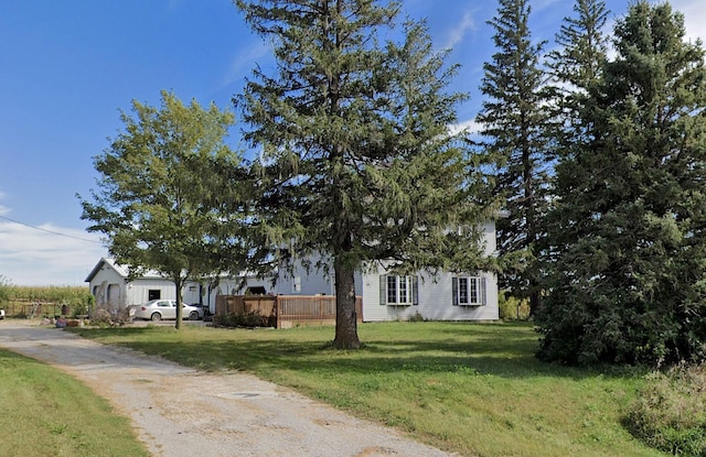 obstructed view of property with a wooden deck and a front yard