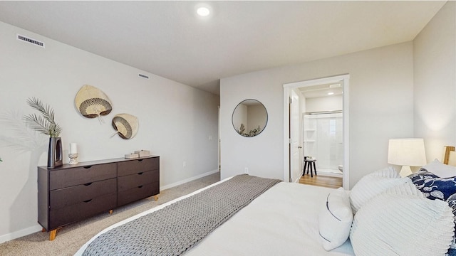 bedroom with light carpet and ensuite bath