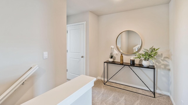 corridor with carpet, baseboards, and an upstairs landing