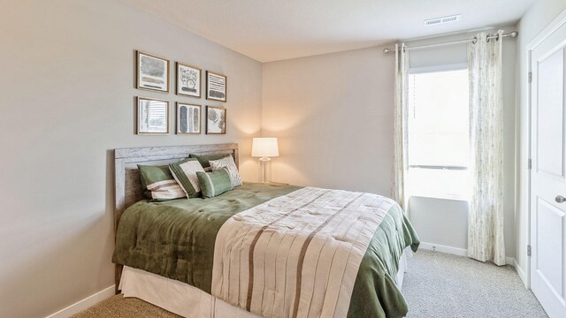 carpeted bedroom with baseboards and visible vents