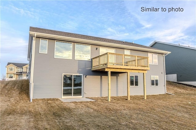 back of house featuring a wooden deck and a yard