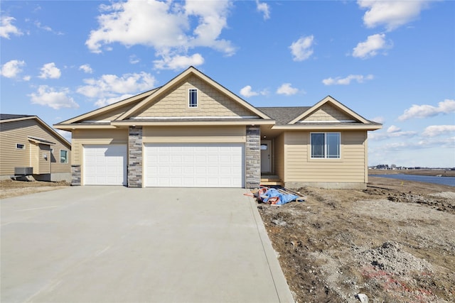 view of front of home featuring driveway, stone siding, an attached garage, and central air condition unit