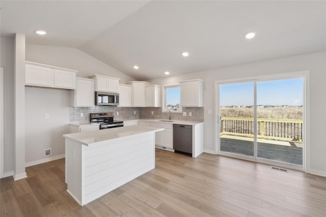 kitchen featuring a sink, visible vents, white cabinets, appliances with stainless steel finishes, and backsplash