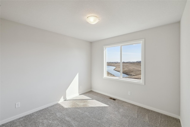 carpeted empty room with baseboards and visible vents