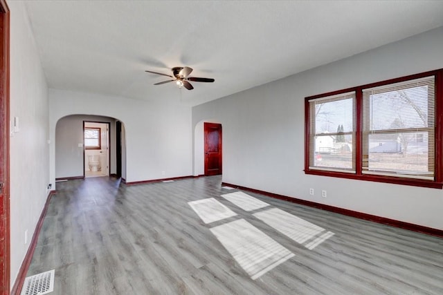 empty room with ceiling fan and light hardwood / wood-style flooring