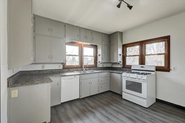 kitchen featuring dark hardwood / wood-style flooring, white appliances, a healthy amount of sunlight, and sink