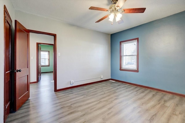 spare room with ceiling fan, a textured ceiling, and light hardwood / wood-style flooring