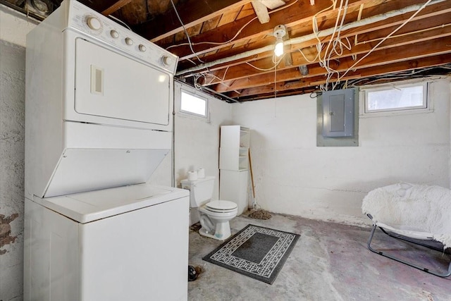 bathroom featuring electric panel, concrete floors, stacked washing maching and dryer, and toilet